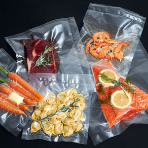 Vakuumierer Vacuum Pro 80 sealing various foods like fish, meat, vegetables, and pasta in vacuum bags.