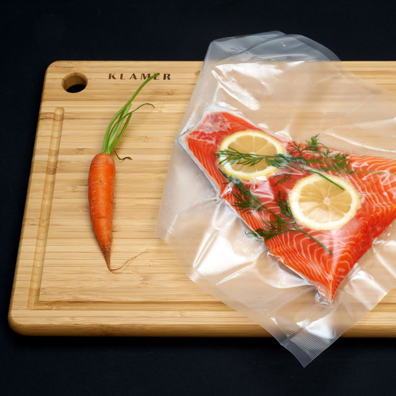 Vakuumierer Vacuum Pro 80 verpackter Lachs mit Zitrone und Dill auf einem Schneidebrett, ideal für Sous Vide zubereitet.